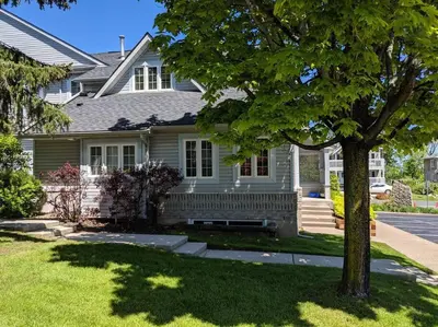 a white house with a tree in the yard at Cozy, 4 Bedroom Chalet, 10 min walk to Village in Blue Mountains