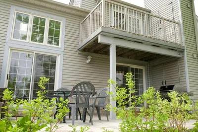a patio with two chairs and a deck on a house at Cozy, 4 Bedroom Chalet, 10 min walk to Village in Blue Mountains