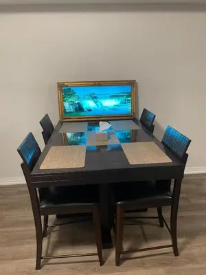 a table with chairs and a laptop on top of it at Modern, well-equipped, and centrally located in Fonthill