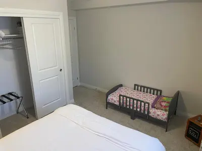 a bedroom with two beds and a baby crib at Modern, well-equipped, and centrally located in Fonthill