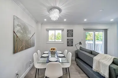 a living room with a table and a couch at 4BR Scarborough Gem, Freshly Renovated, 7 Car Parking in Toronto