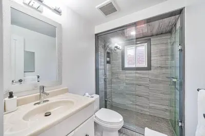 a bathroom with a toilet and a sink and a shower at 4BR Scarborough Gem, Freshly Renovated, 7 Car Parking in Toronto