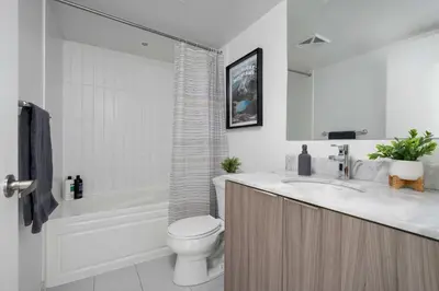 a bathroom with a tub and a toilet and a sink at Pleasant 1BR Sofa Bed Close to UofT in Toronto