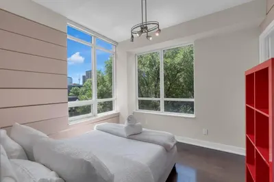 a bedroom with a bed and two windows at 1560 sqft Elegant Condo at Downtown Hi-End Shopping & Dining Area - CN Tower View, Bidet, LockBox in Toronto