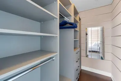a walk in closet with white shelves and a mirror at 1560 sqft Elegant Condo at Downtown Hi-End Shopping & Dining Area - CN Tower View, Bidet, LockBox in Toronto