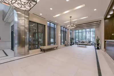 a lobby of a building with benches and windows at 1560 sqft Elegant Condo at Downtown Hi-End Shopping & Dining Area - CN Tower View, Bidet, LockBox in Toronto
