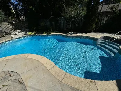 a swimming pool with blue water in a yard at Leaside Rental with Great Backyard & Pool in Toronto