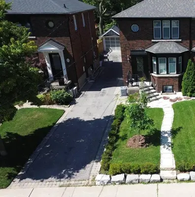 a brick house with a tree in a yard at Leaside Rental with Great Backyard & Pool in Toronto