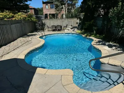 a small swimming pool with blue water in a yard at Leaside Rental with Great Backyard & Pool in Toronto