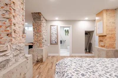 a bedroom with a brick wall and a bed at ENTIRE 1 BEDROOM APARTMENT ACROSS FROM GOOGLE - br1 in Kitchener