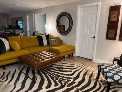 a living room with a yellow couch and a rug at Luxurious Private Apartment in Oakville