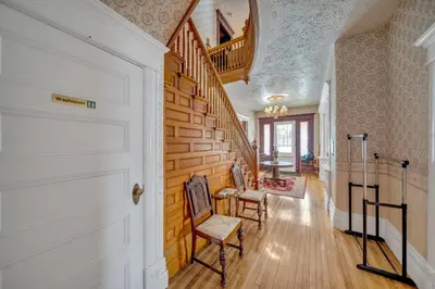 a hallway with a wooden staircase with chairs in a house at Marmora and Lake Inn and Victorian Diner - Grand Victorian Suites- Level 2 in Marmora