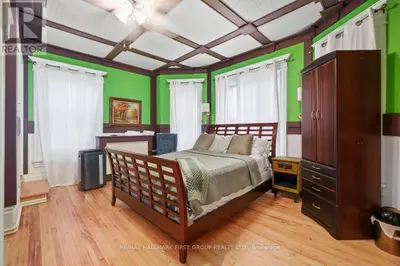 a bedroom with a bed and a green wall at Marmora and Lake Inn and Victorian Diner - Grand Victorian Suites- Level 2 in Marmora