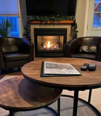 a living room with a coffee table and a fireplace at Stone Mill Retreat - Rustic Cozy Getaway with Loft! in Fergus