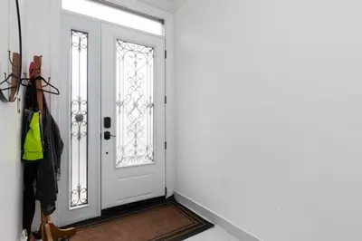 a hallway with a white door and a rug at Grand 3 BR Toronto Victorian Entire Home in Toronto