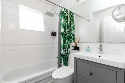 a bathroom with a toilet and a sink and a shower curtain at Grand 3 BR Toronto Victorian Entire Home in Toronto