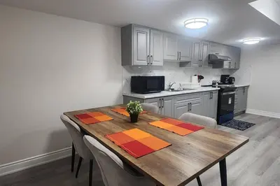 a kitchen with a wooden table with chairs around it at Cozy Hideaway in Thorold