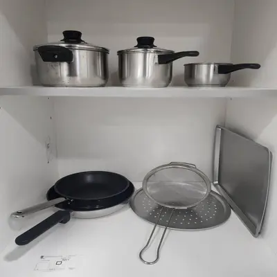 a stove top with two pots and a pan on it at Cozy Hideaway in Thorold