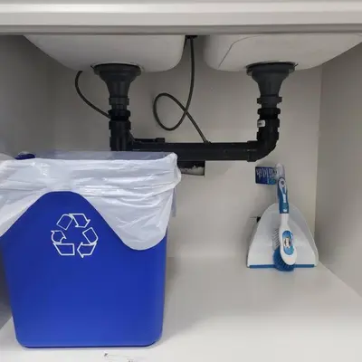 a blue trash can under a bathroom sink at Cozy Hideaway in Thorold