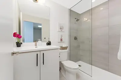 a white bathroom with a toilet and a shower at Newly Built Condo with Amazing Views in Kitchener