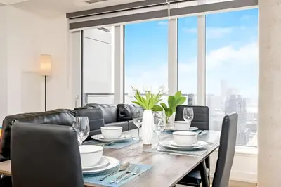 a dining room with a table and chairs and windows at Newly Built Condo with Amazing Views in Kitchener