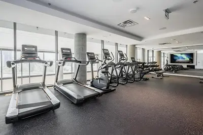 a gym with rows of treadms and cardio machines at Newly Built Condo with Amazing Views in Kitchener