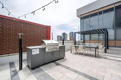 a patio with a grill and a table on a building at Newly Built Condo with Amazing Views in Kitchener