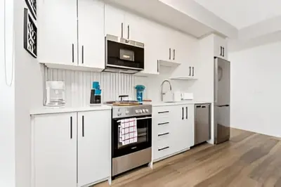 a kitchen with white cabinets and a stove top oven at Newly Built Condo with Amazing Views in Kitchener