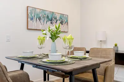 a dining room table with a vase of flowers on it at Modern High Rise King bed Condo with Private Balcony in Kitchener