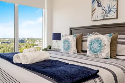 a bedroom with a large bed with blue and white pillows at Modern High Rise King bed Condo with Private Balcony in Kitchener