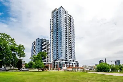 a tall building in a city with a park at Modern High Rise King bed Condo with Private Balcony in Kitchener