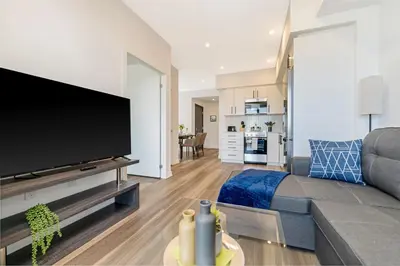 a living room with a couch and a flat screen tv at Modern High Rise King bed Condo with Private Balcony in Kitchener