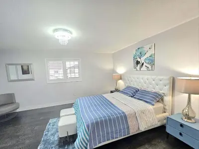 a bedroom with a bed with a blue and white blanket at Beautiful 3 bedroom Entire detached home in Whitby
