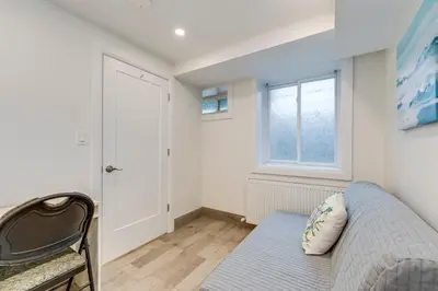 a living room with a couch and a window at Midtown 2 Bedroom Apartment in Toronto