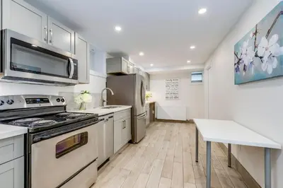 a kitchen with white cabinets and a stove top oven at Midtown 2 Bedroom Apartment in Toronto