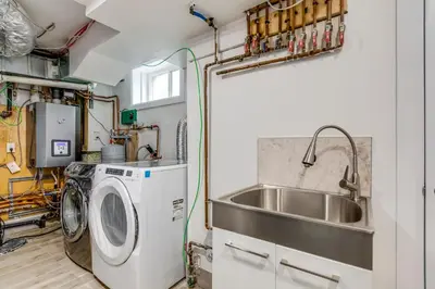 a kitchen with a sink and a washing machine at Midtown 2 Bedroom Apartment in Toronto