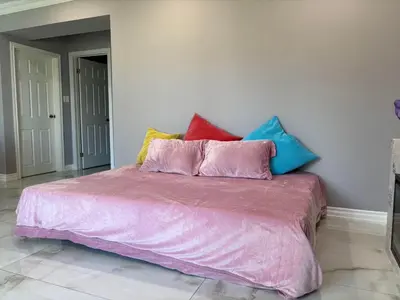 a bed with colorful pillows on top of it at Willowdale in Toronto