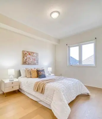 a white bedroom with a large bed and a window at Bright bedroom with private bathroom in Richmond Hill