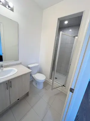 a bathroom with a toilet and a sink and a shower at Bright bedroom with private bathroom in Richmond Hill