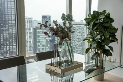 a glass table with two vases and plants on it at Bright bedroom with private bathroom in Richmond Hill