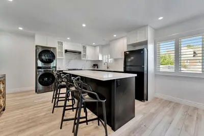 a kitchen with black appliances and white cabinets at Luxe Lodges Lake Erie in Port Dover