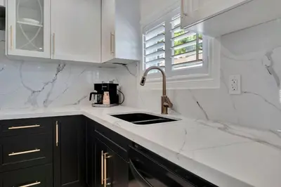 a kitchen with white marble counter tops and a sink at Luxe Lodges Lake Erie in Port Dover