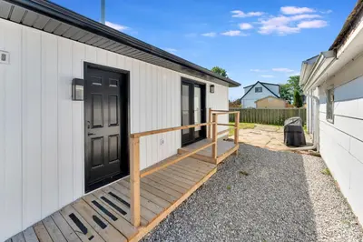 a porch with a black door on a white building at Luxe Lodges Lake Erie in Port Dover
