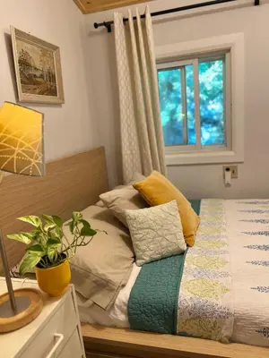 a bedroom with a bed with a window at Birkswyld waterfront cottage Mary Lake in Huntsville