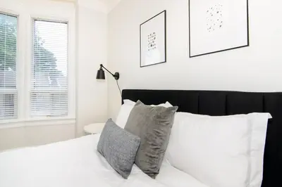 a bedroom with a bed with white sheets and pillows at RentX 3Bed Cozy Home - Hospital GO 2ParkingWi-Fi in Hamilton