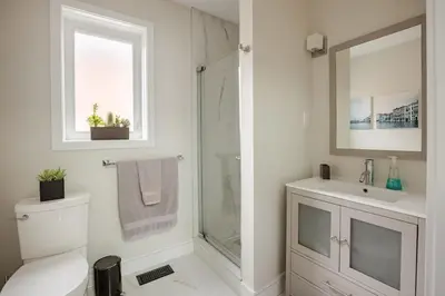 a bathroom with a shower and a toilet and a sink at Lonborough Ave Upstairs in Toronto