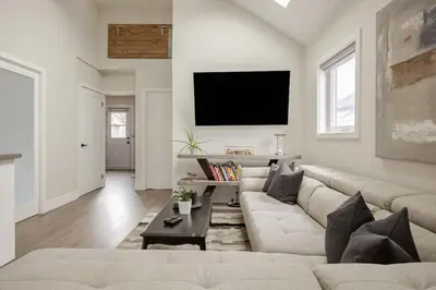 a living room with a couch and a flat screen tv at Lonborough Ave Upstairs in Toronto