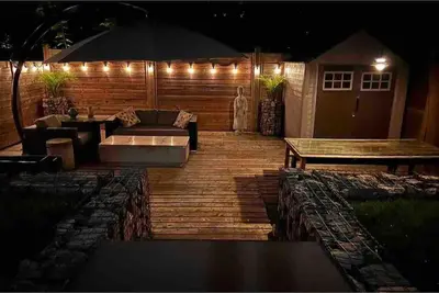 a deck with a couch and a table and an umbrella at Lonborough Ave Upstairs in Toronto