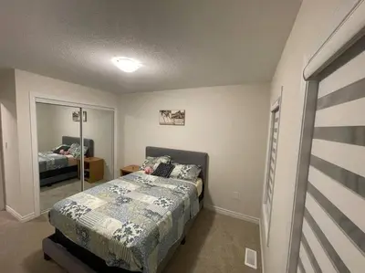 a bedroom with a bed and a mirror at Cozy 3-Bedrooms T-Home #Niagara in Thorold