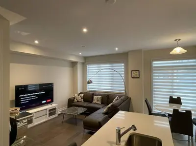 a living room with a couch and a tv at Cozy 3-Bedrooms T-Home #Niagara in Thorold